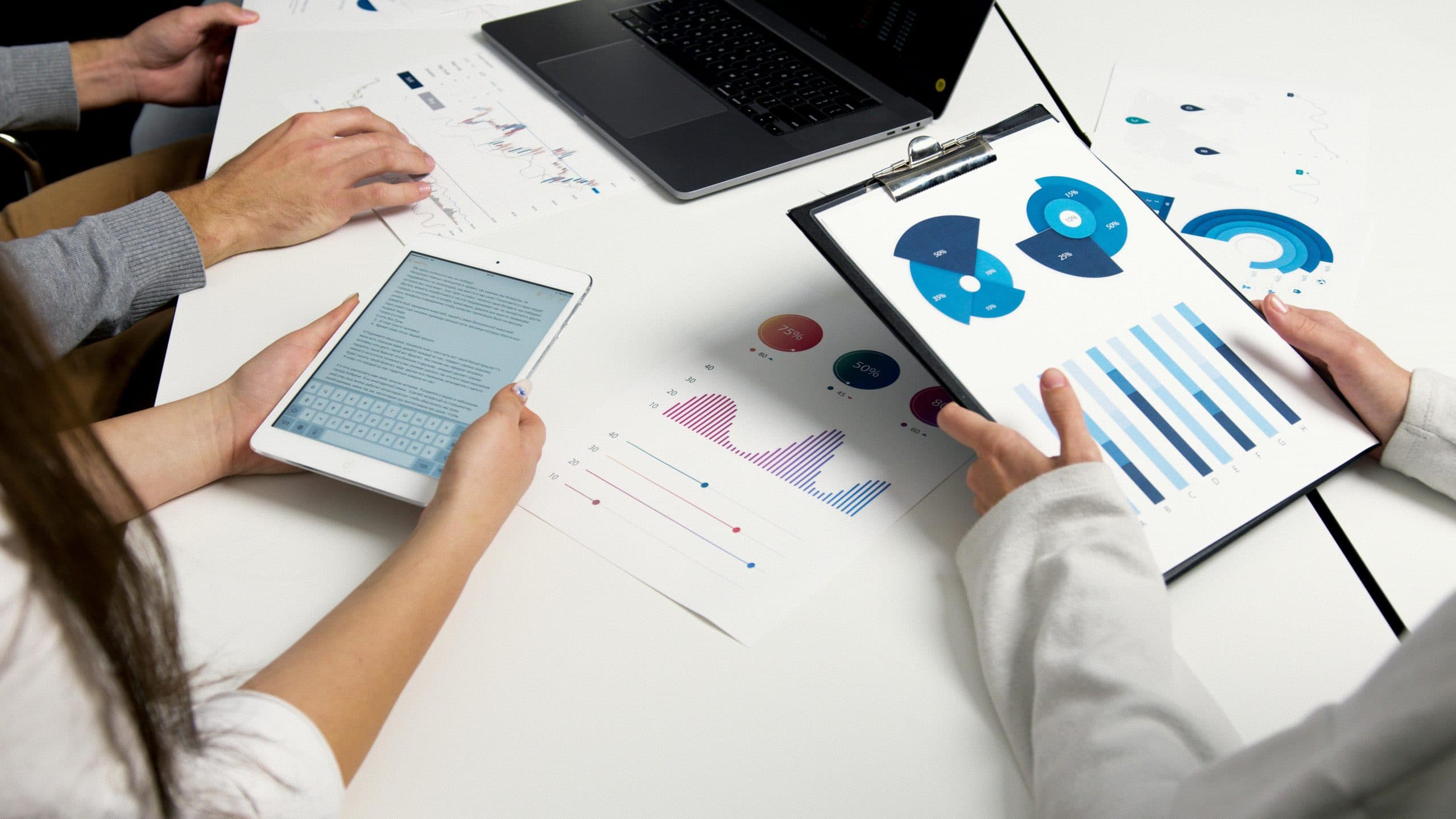 Enterprise team reviewing printed data charts and graphs during a strategy meeting, symbolising collaboration and domain ownership in data mesh implementation and governance planning.